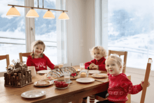 Why Butter Braid Pastries Make a Great Gift - kids dressed in Christmas sweaters sitting around kitchen table with pastry in the center