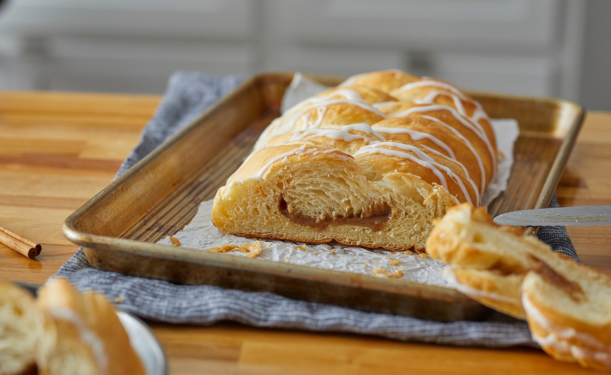 Cinnamon Butter Braid Pastry on baking pan, partially cut into slices.