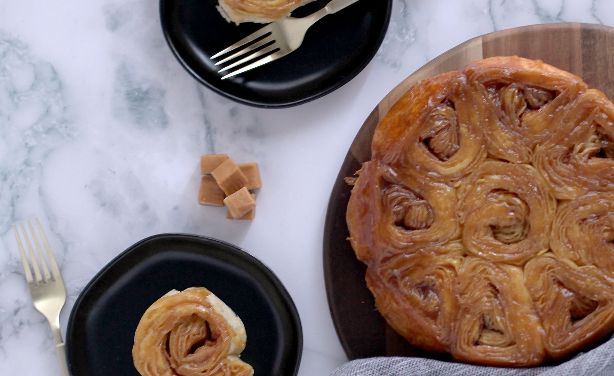 Caramel Pastry Rolls together on a serving platter with two rolls on plates. Caramel candy pieces used as garnish.