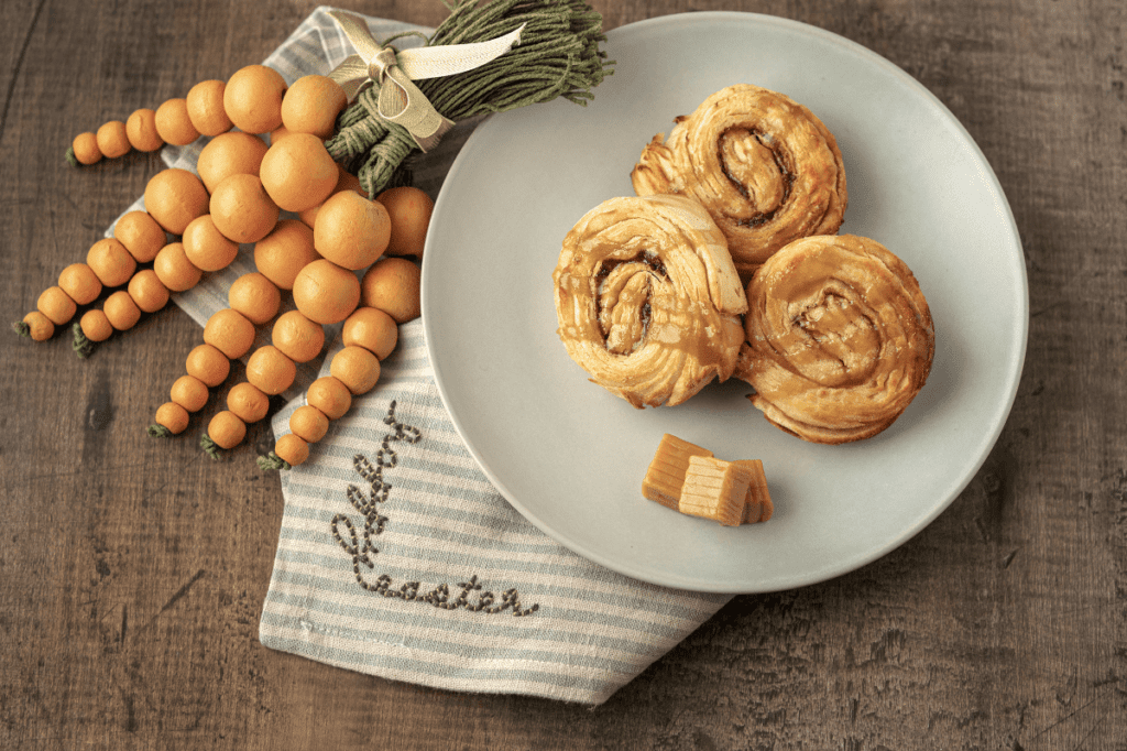 Deep-Fried Caramel Rolls on plate next to carrot décor and a cloth napkin.