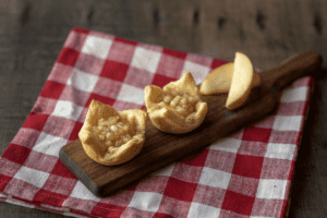 Apple Pie Pastry Cups on cutting board with a gingham napkin