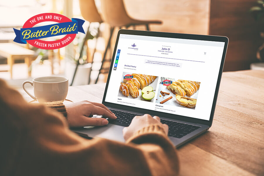 A person is sitting at a laptop that shows a Butter Braid® Pastry online store for a local fundraiser.