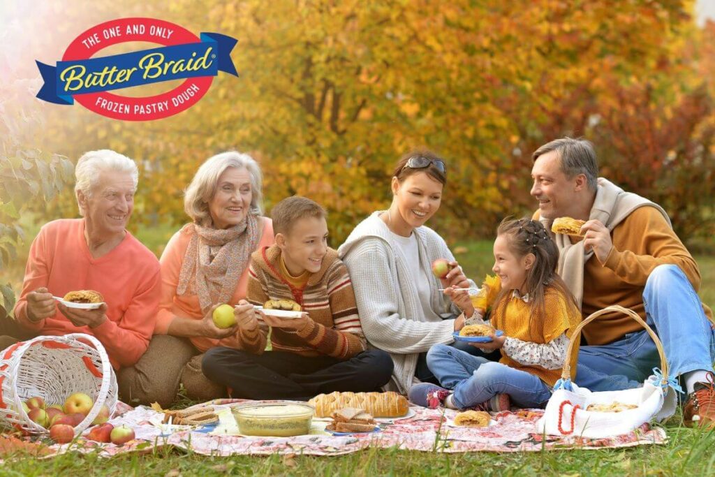 Secrets to Successful Fundraising #4 - Have a Great Product Experience - multigenerational family having a picnic, eating slices of a Cinnamon pastry. Apples, bread, and other baked goods are also on the picnic blanket.