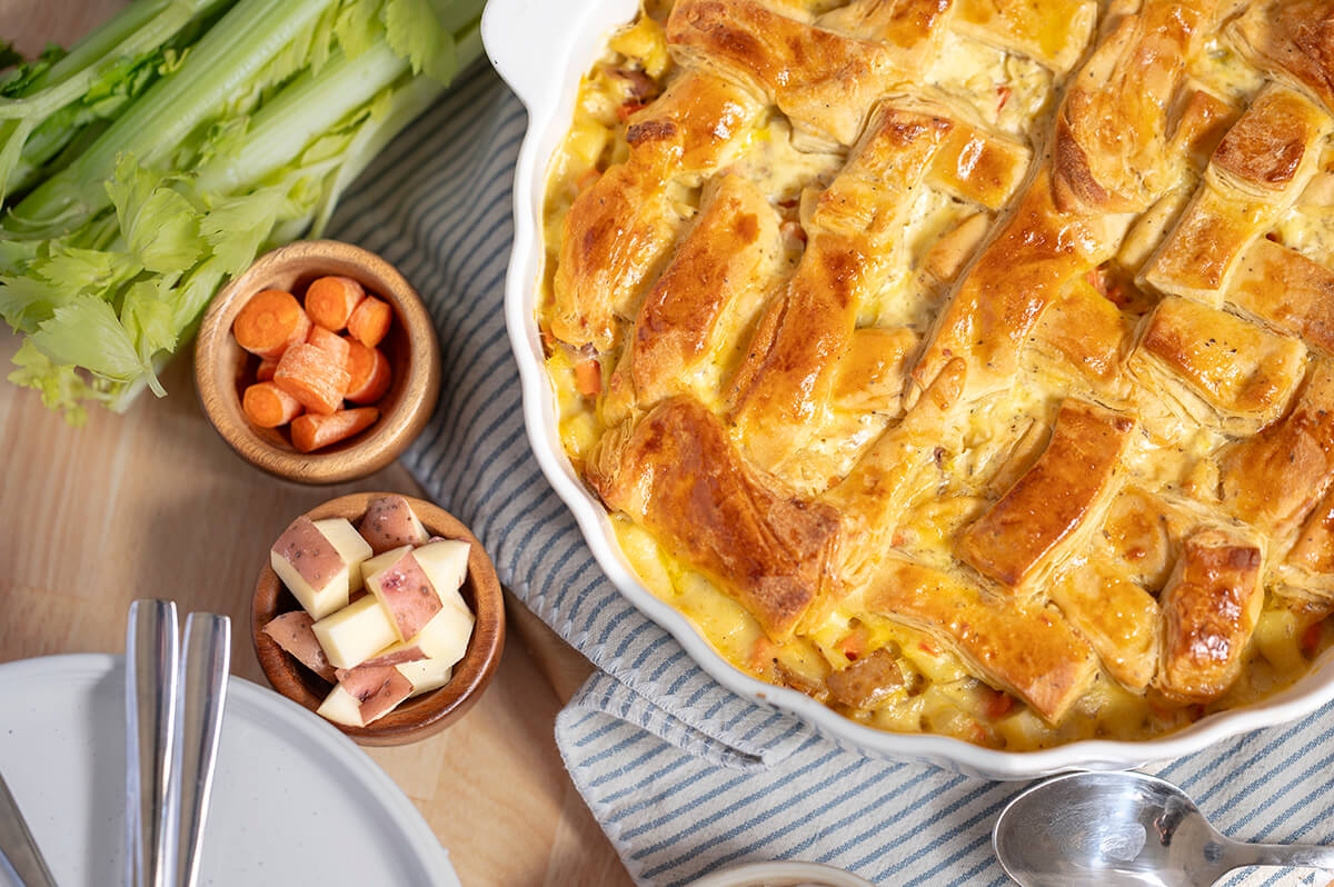 Homemade Chicken Pot Pie in a dish surrounded by bowls of ingredients.